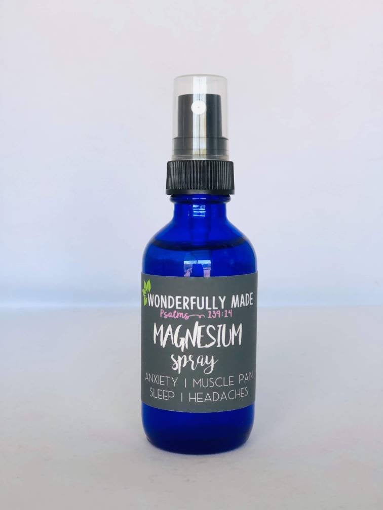 Single cobalt blue glass bottle of topical magnesium spray with a fine-mist pump and wellness label, displayed on a white background for daily mineral supplementation and self-care routines.
