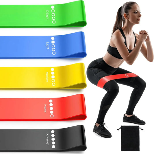 Five color-coded TPE resistance loop bands with light to extra-heavy resistance levels beside an athlete performing banded squats. Includes a portable storage bag for home, gym, yoga, and strength training.