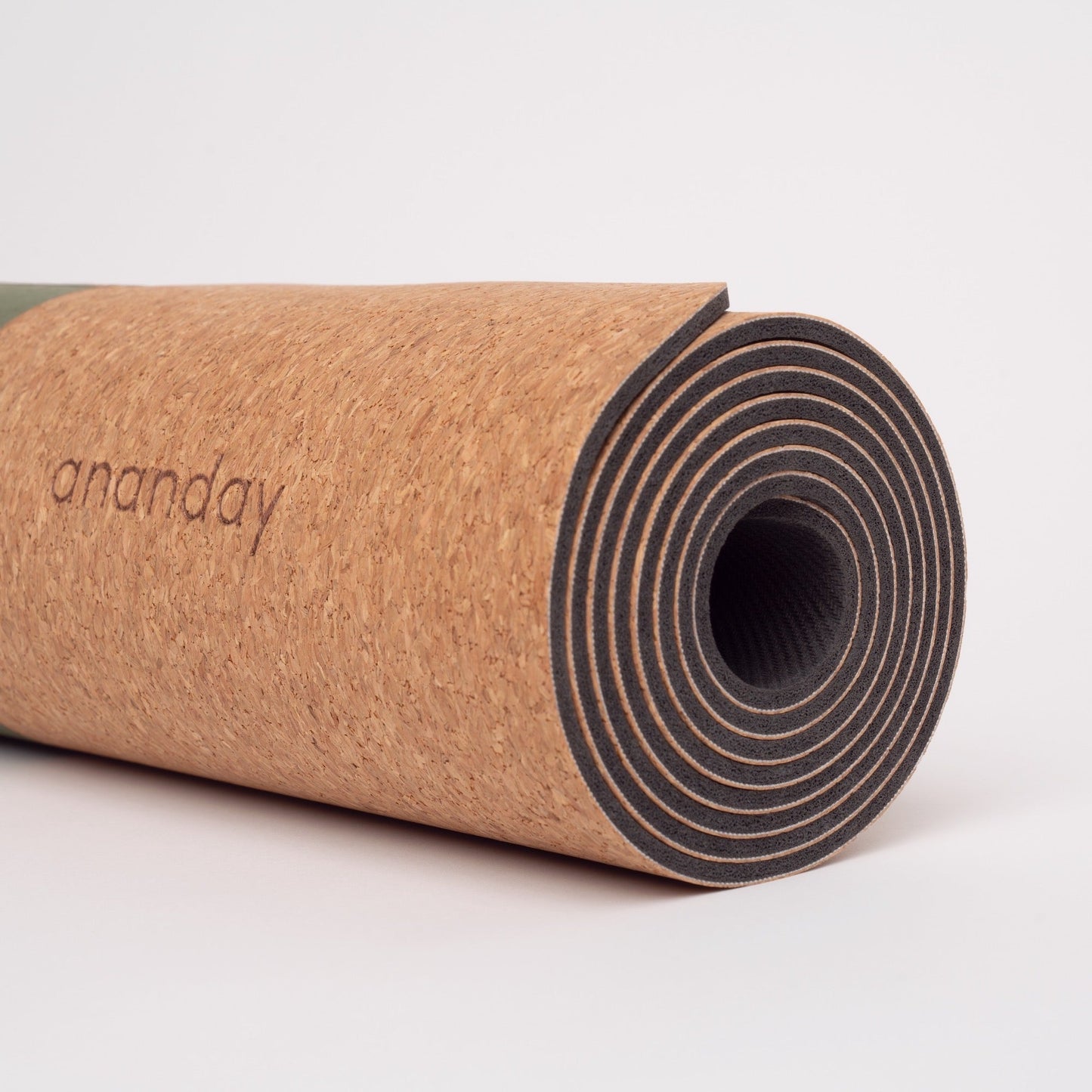 Rolled Ananday cork yoga mat featuring a natural cork surface and cushioned rubber base, showcasing its durable, eco-friendly construction for yoga, Pilates, stretching, and fitness workouts.