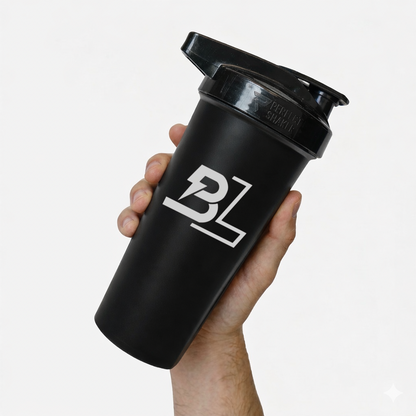 Hand holding a black BLACKLABEL 28 oz protein shaker bottle with flip-top lid and white logo against a clean white background, ideal for mixing protein shakes, pre-workout, and hydration drinks.